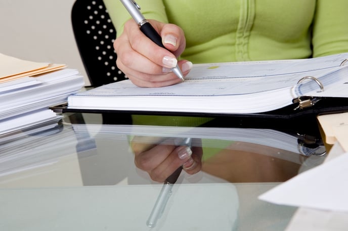 Writing a check on a glass table.